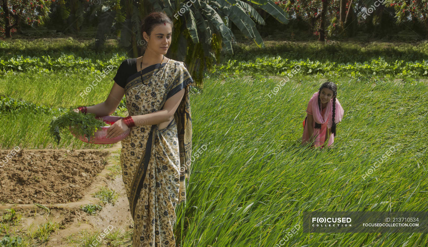 Indian mother with daughter on green farm field at sunny day — eco ...