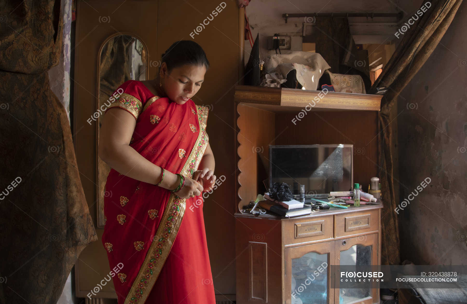 Indian woman in red saree getting ready — bangles, standing - Stock ...