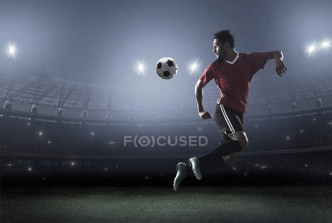 Футболист демонстрирует мастерство с мячом на стадионе — стоковое фото