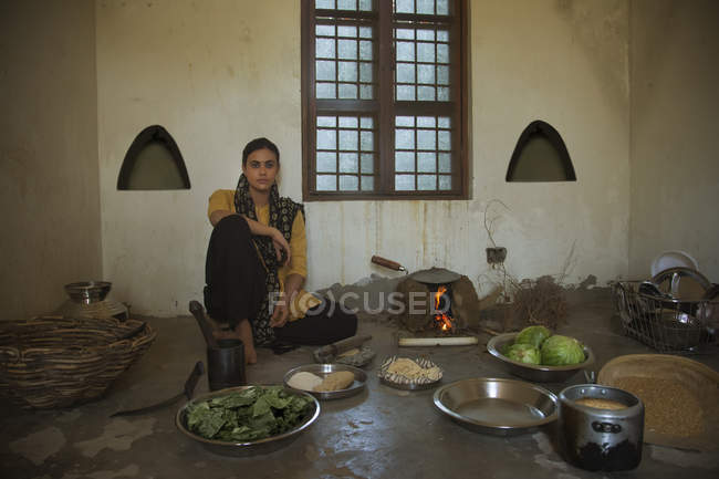 Femme indienne assise dans la cuisine sur le sol — Photo de stock