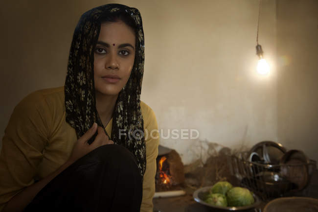 Mujer india sentada en la cocina en el suelo - foto de stock