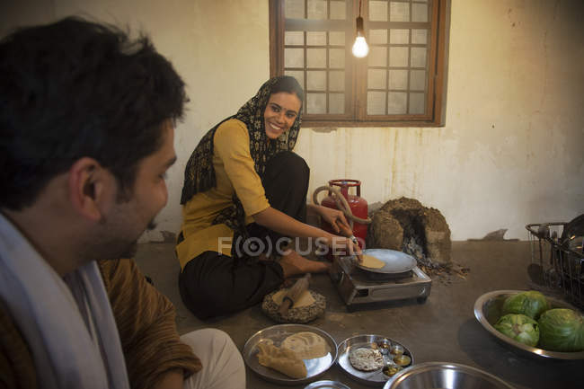 Indian family cooking food on floor indoors — Stock Photo