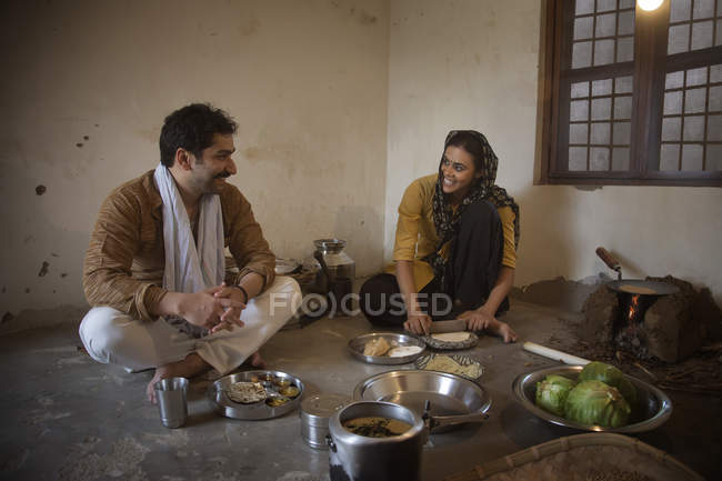 Indian family cooking food on floor indoors — Stock Photo