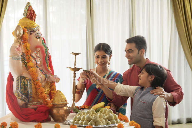 Família em roupas festivas realizando aarti em Ganesh chaturthi — Fotografia de Stock