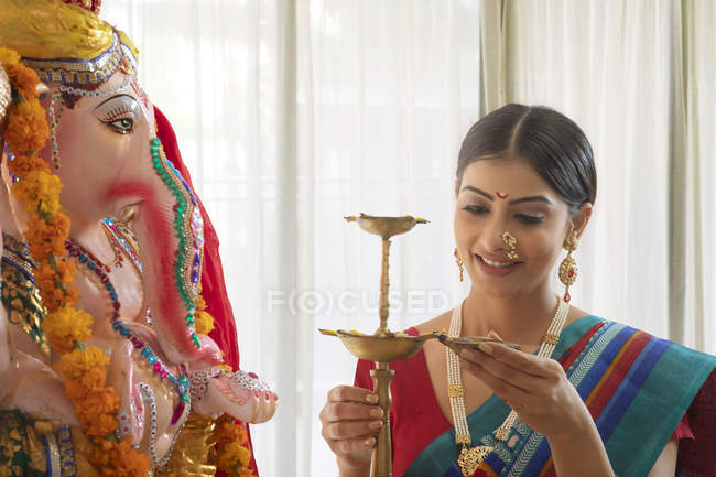 Woman lighting up diya preparing for Ganpati pooja on Ganesh Chaturthi — Stock Photo