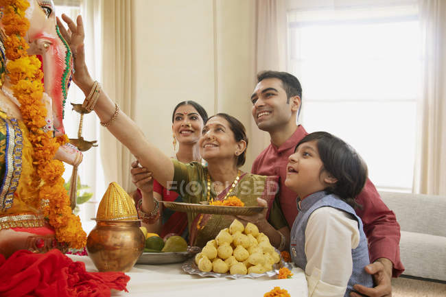 Індійська сім'ї в святковий одяг святкування Ганеш chaturthi в приміщенні — стокове фото