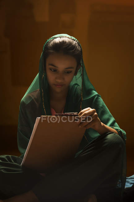 Portrait de fille indienne regardant tampon d'examen sous la lumière du dos — Photo de stock