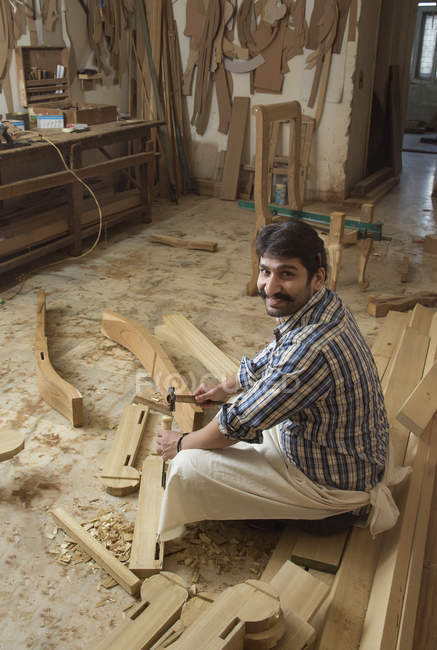 Vue grand angle du menuisier souriant travaillant en atelier — Photo de stock