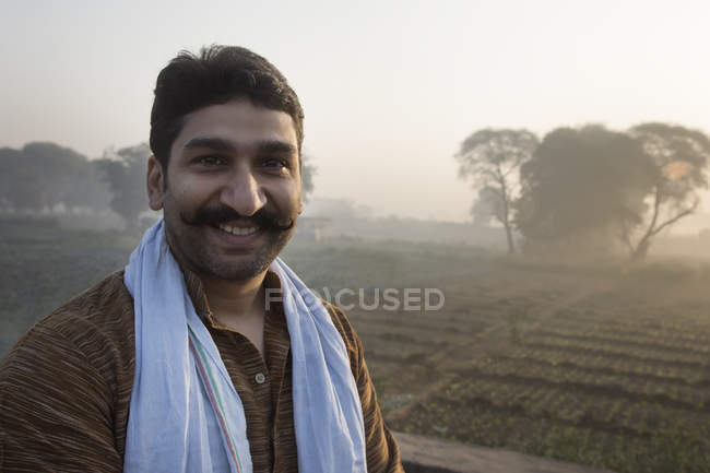 Retrato de agricultor masculino en el campo agrícola contra el sol en el fondo - foto de stock