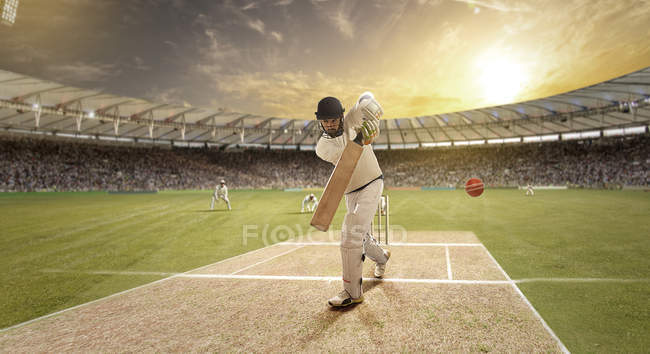 Jovem desportista bola impressionante enquanto rebatendo no campo de críquete — Fotografia de Stock