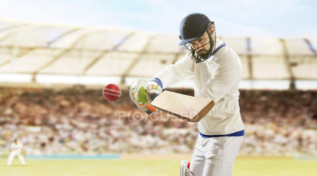 Junger Sportler schlägt Ball, während er auf Cricketfeld zuschlägt, selektiver Fokus — Stockfoto
