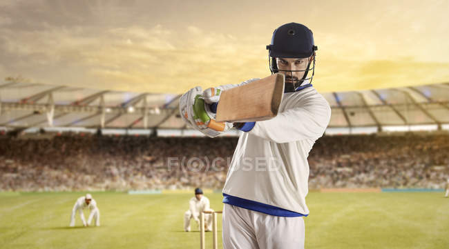 Junger Sportler schlägt Ball, während er auf Cricketfeld zuschlägt, selektiver Fokus — Stockfoto