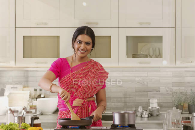 Жінка в сарі готує на кухні — стокове фото