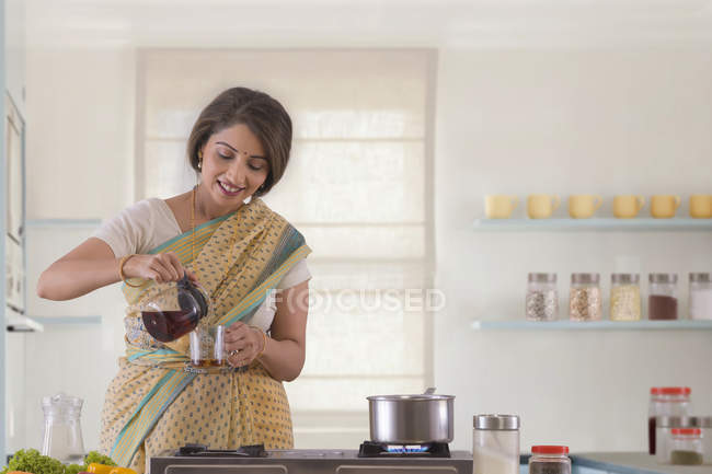 Woman pouring tea in a cup — Stock Photo