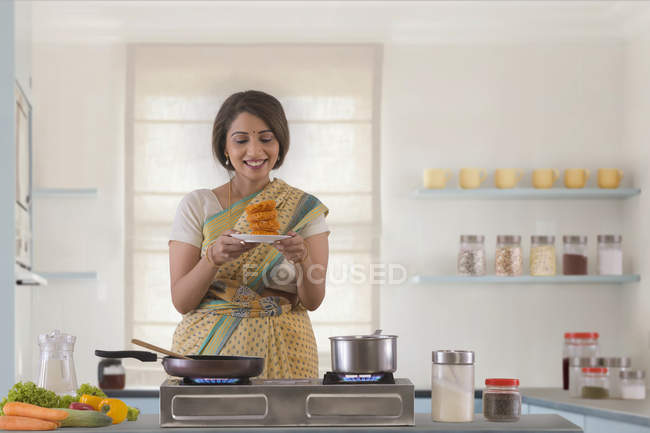 Жінка тримає солодку страву на кухні. — стокове фото