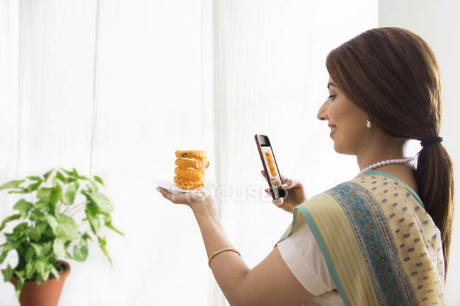 Donna cliccando foto di dolce piatto in mano — Foto stock