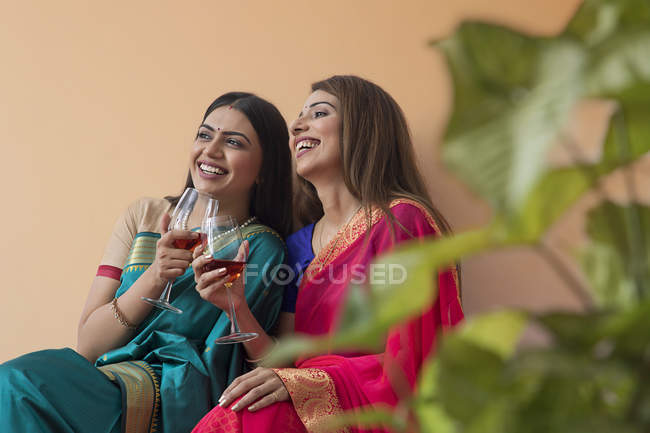 Women in saree having a drink together — Stock Photo