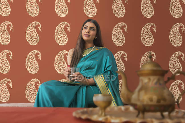 Mulher em saree tomando chá em casa — Fotografia de Stock