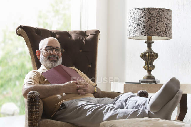Старший мужчина расслабляется в своем доме — стоковое фото