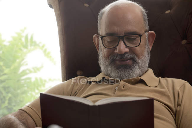 Пожилой человек, читающий книгу — стоковое фото