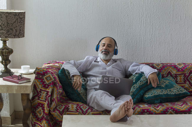 Hombre mayor escuchando música y relajándose - foto de stock