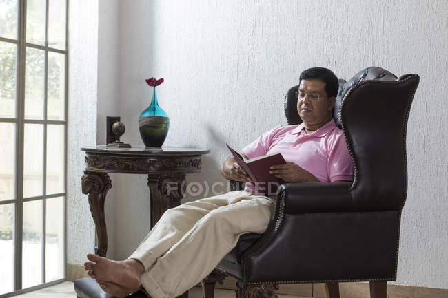 Man sitting on a chair and looking outside — Stock Photo
