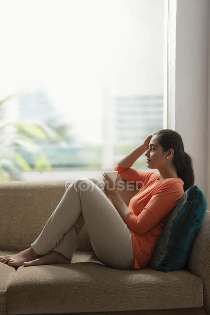 Donna rilassante sul divano — Foto stock