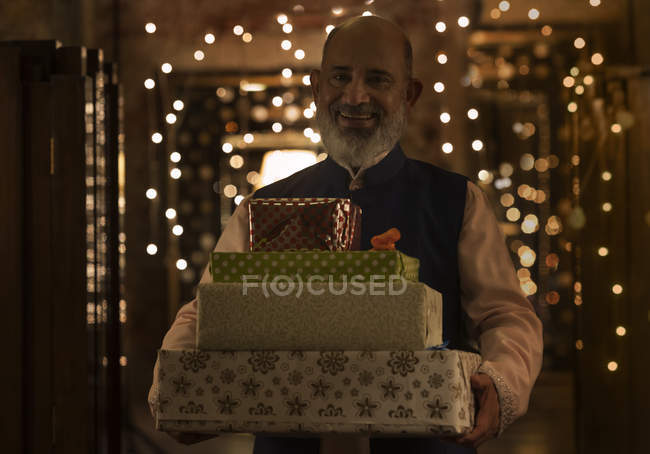 Portrait of a senior man standing with gifts — Stock Photo