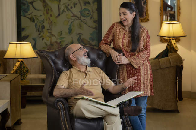 Ein älteres Paar, das sich im Wohnzimmer anschaut und lächelt. — Stockfoto
