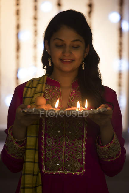Retrato de uma jovem mulher em pé no cargo com uma bandeja de diyas durante as celebrações de Diwali . — Fotografia de Stock