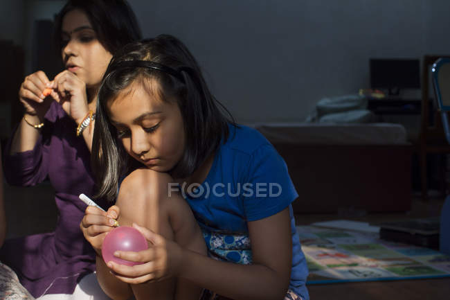 Девушка рисует на воздушных шарах — стоковое фото