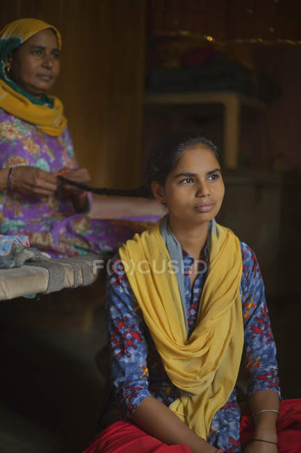 Мать плетёт дочери косички — стоковое фото