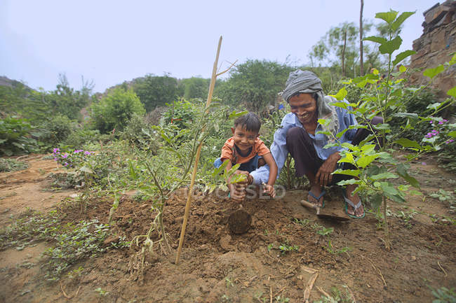Vecchio che insegna l'agricoltura a un bambino nel campo — Foto stock