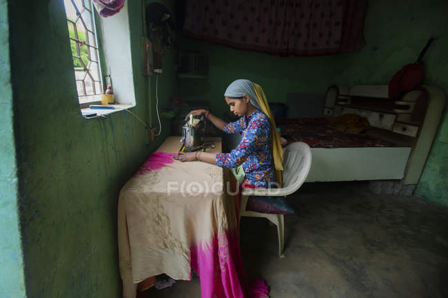Young girl Stitching with a sewing machine — Stock Photo
