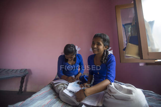School girls laughing while studying at home — Stock Photo