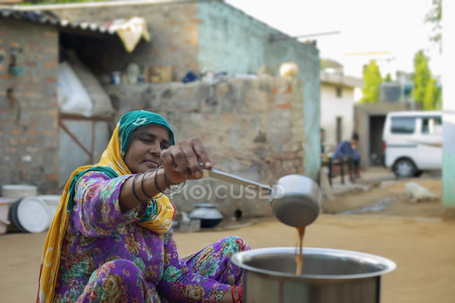 Жінка робить чай у великій сковороді — стокове фото