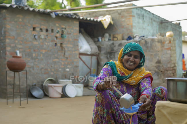 Femme verser joyeusement le thé dans un verre — Photo de stock