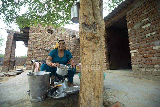 Frau putzt Utensilien auf ihrer Veranda — Stockfoto