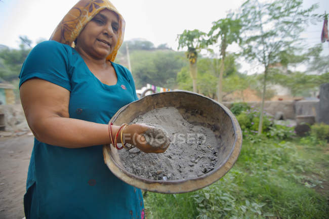 Mujer que usa ceniza como fertilizante - foto de stock