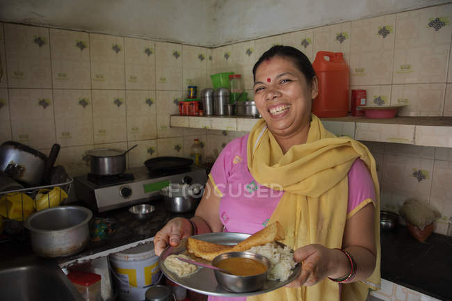 Портрет усміхненої жінки, що пропонує їжу — стокове фото