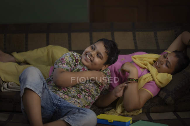 Junge legt sich mit seiner Mutter auf Sofa — Stockfoto