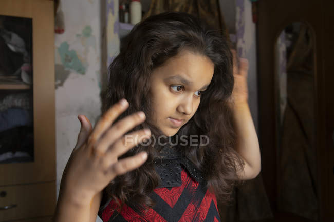 Jovem menina amarrando seu cabelo — Fotografia de Stock