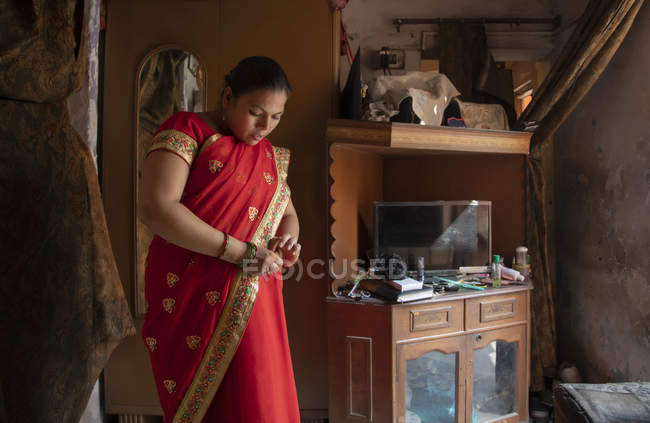 Indian woman in red saree getting ready — Stock Photo