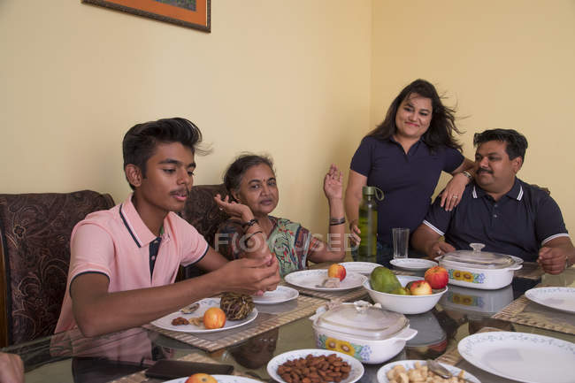 Glückliche Familie sitzt zu Hause am Esstisch. — Stockfoto