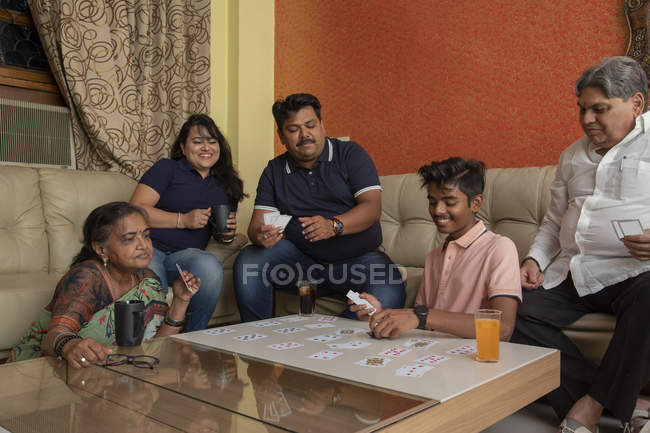 Happy family playing with cards in the living room at home. — Stock Photo