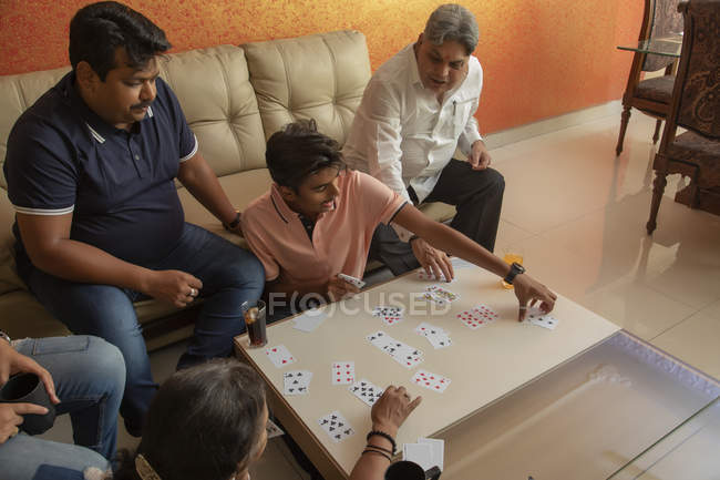 Щаслива сім'я грає з картами у вітальні вдома . — стокове фото