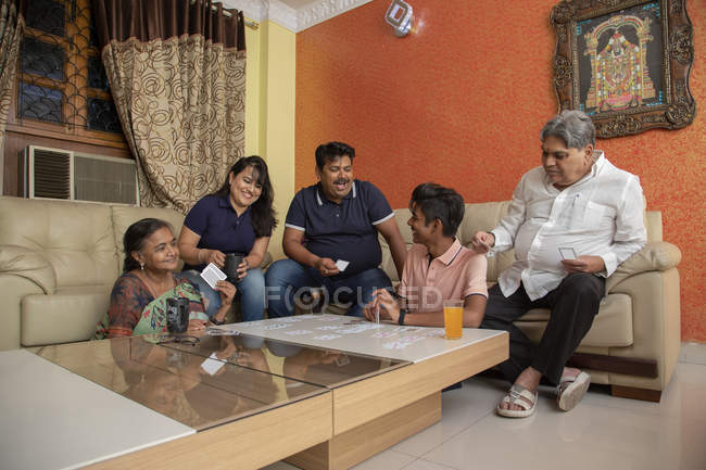 Família feliz jogando com cartões na sala de estar em casa . — Fotografia de Stock