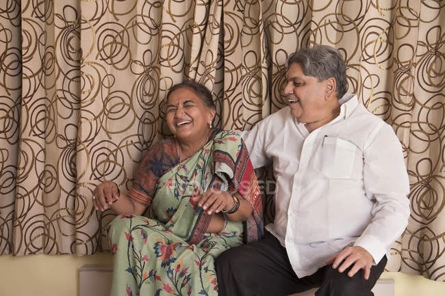 Senior couple sitting on the stairs at home. — Stock Photo
