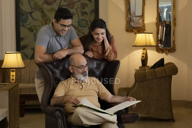 Father, mother and son are looking at a book. (Family) — Stock Photo