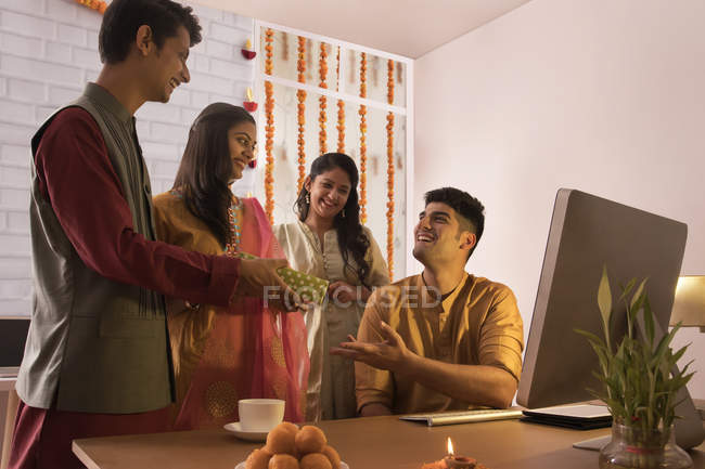 Сотрудники, дарящие подарок коллеге в офисе по случаю празднования Дивали . — стоковое фото